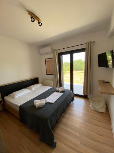 - une chambre avec un lit et une grande fenêtre dans l'établissement Thespis Villa 1, à Sikia