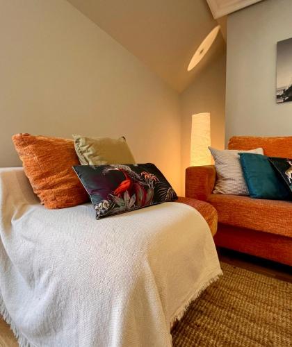 a room with a bed with colorful pillows on it at Rías Altas Home Sada in Sada