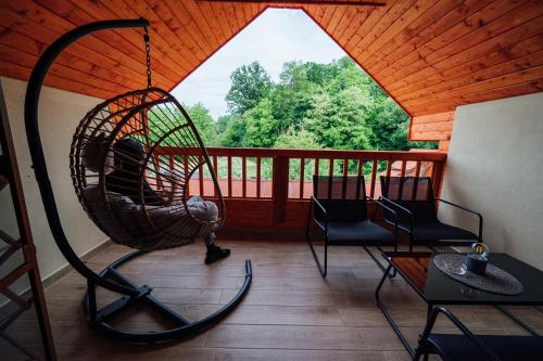 a porch with a swing and chairs on a roof at Pensiunea Comfort in Sovata