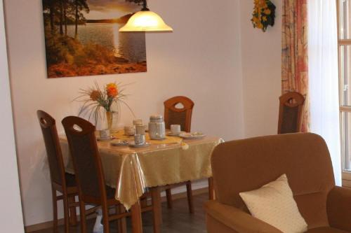 uma mesa de jantar com uma toalha de mesa amarela e cadeiras em Ferienwohnung Stoiber Wolfgang em Regen