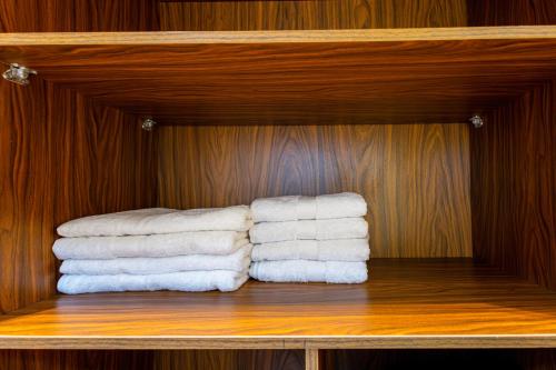 a group of towels on a wooden shelf at Marron studios 2 new in Cairo