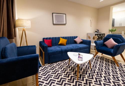 ein Wohnzimmer mit 2 blauen Sofas und einem Tisch in der Unterkunft Marron studios 2 new in Kairo
