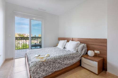 a bedroom with a bed and a balcony at Lopimar Guillen de Castro in Canet de Berenguer