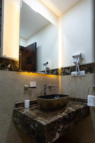 uma casa de banho com um lavatório de pedra e um espelho. em Marron studios 2 new no Cairo