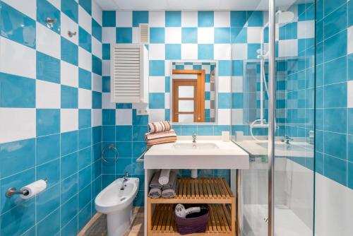 a blue and white bathroom with a sink and a toilet at Lopimar Guillen de Castro in Canet de Berenguer