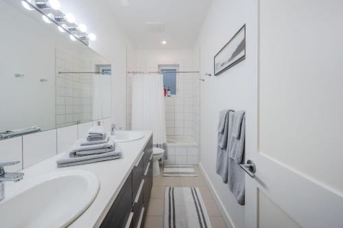 a white bathroom with a sink and a toilet at Evergreen Condo by Leavetown Vacations in Penticton