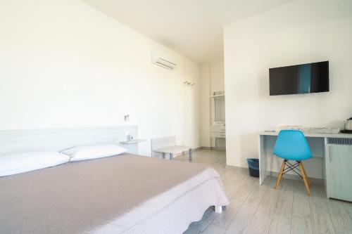 a white bedroom with a bed and a blue chair at Borgo Albador Rooms in Posada