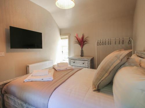 a bedroom with a large bed with a flat screen tv at Number 4 in Telford