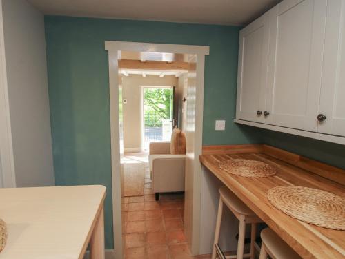 uma cozinha com paredes verdes e bancadas de madeira em Number 5 em Telford