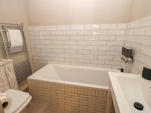 a bathroom with a white tub and a toilet at Number 7 in Telford