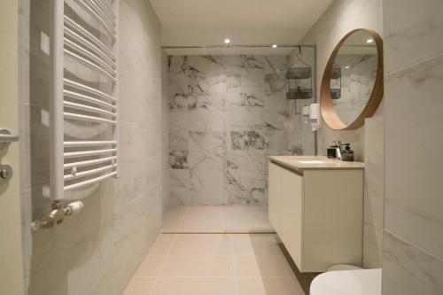 a white bathroom with a sink and a mirror at Belgrade Waterfront - River Residence in Belgrade