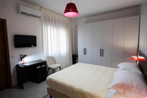 1 dormitorio con 1 cama, escritorio y TV en B&B Torre Talao, en Scalea