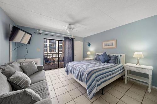 1 dormitorio con 1 cama y 1 sofá en Sugar Beach 110 condo, en Gulf Shores