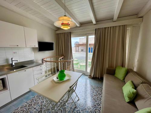 uma cozinha e uma sala de estar com um sofá e uma mesa em Cala del Porto Residence em Marettimo