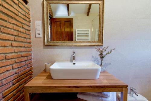 a bathroom with a white sink and a mirror at El Molino de Bonaco in San Vicente de la Barquera