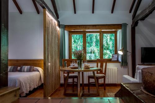 um quarto com uma mesa, uma cama e uma janela em El Molino de Bonaco em San Vicente de la Barquera