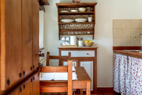 uma cozinha com uma mesa de madeira e uma cadeira de madeira em El Molino de Bonaco em San Vicente de la Barquera
