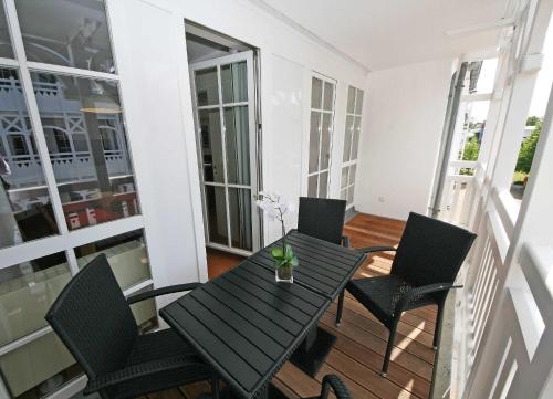 a black table and chairs on a balcony at Seepark Sellin Haus Altensien - Ferienwohnung 465 mit Balkon in Ostseebad Sellin