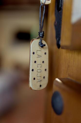 a tag hanging from a wooden door at El Molino de Bonaco in San Vicente de la Barquera