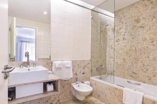 ein Badezimmer mit einem Waschbecken, einem WC und einer Badewanne in der Unterkunft Vilamoura Marina Lake in Vilamoura