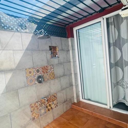 ein Badezimmer mit Dusche mit Fliesen und Fenster in der Unterkunft Bungalow Verdemar Maspalomas in Maspalomas