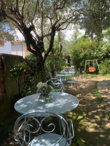 einen Tisch mit Stühlen und eine Vase mit Blumen darauf in der Unterkunft Enzo’s House in Lucca