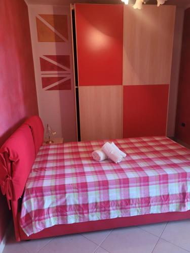 um pequeno quarto com uma cama com um cobertor xadrez em Il risveglio em Codrongianos