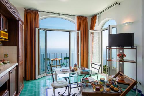 a living room with a table and a view of the ocean at Amalfi Residence in Conca dei Marini