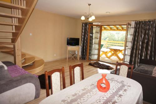 a living room with a table and a dining room with a view at Apartamenty Dzika Orlica in Zieleniec