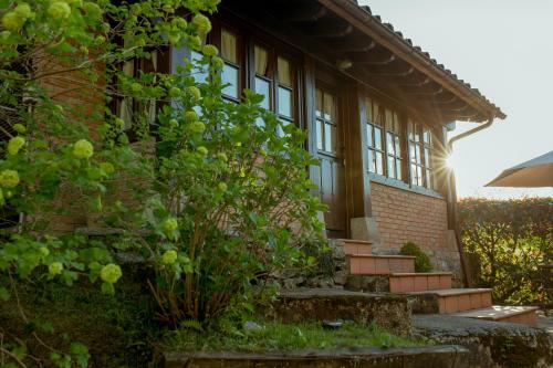 a house with windows and a bush in front of it at El Molino de Bonaco in San Vicente de la Barquera