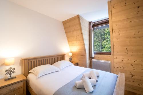 een slaapkamer met een groot bed en handdoeken bij Résidence Le Paradis in Chamonix-Mont-Blanc