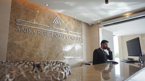 a man talking on a cell phone in an office at Anisa Residential Complex in Salalah