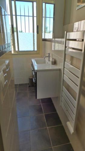 une salle de bain avec un lavabo et une fenêtre dans l'établissement Courrier sud 1918, aux Issambres