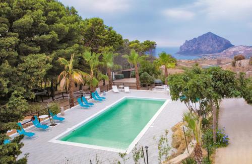 una piscina con sedie e l'oceano sullo sfondo di Villa Panoramica sul Mare a Valderice