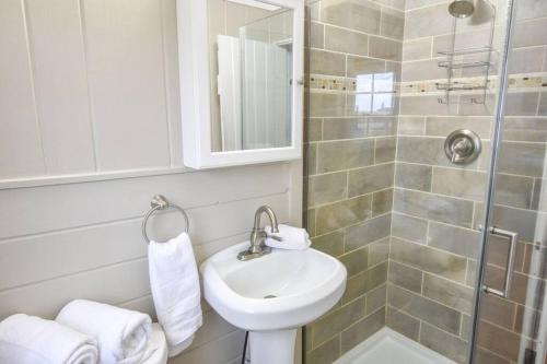 y baño con lavabo y ducha. en Across from Mayo beach walk to downtown, en Wellfleet