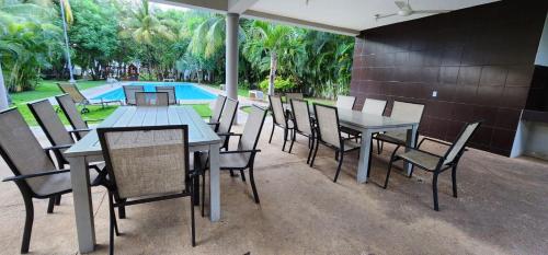 Hermosa Casa en Jardines Cancún في كانكون: فناء به طاولات وكراسي ومسبح