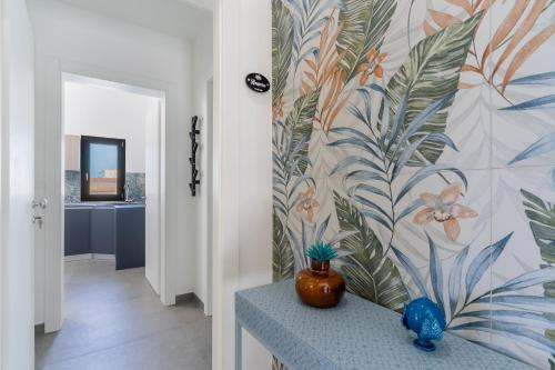 a hallway with a wall mural with a vase on a counter at Residence Medusa by BarbarHouse in Porto Cesareo