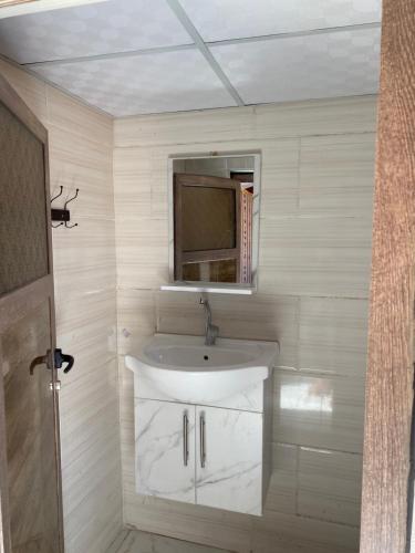 łazienka z białą umywalką i oknem w obiekcie Wadi Rum Sand Camp w mieście Disah
