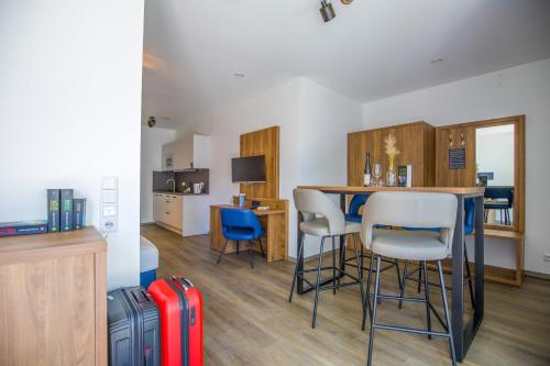 a living room with a table and chairs and a kitchen at BUDE16 Boardinghouse in Norden
