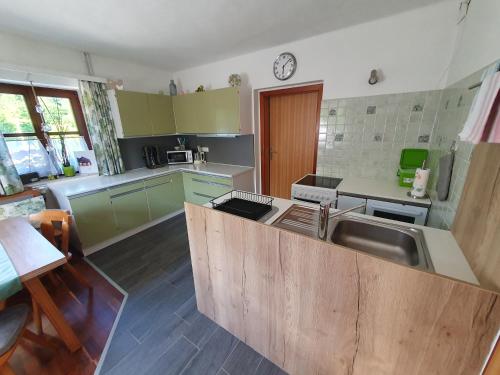 a kitchen with green cabinets and a wooden counter top at Ferienwohnung Michaela in Lackenhof