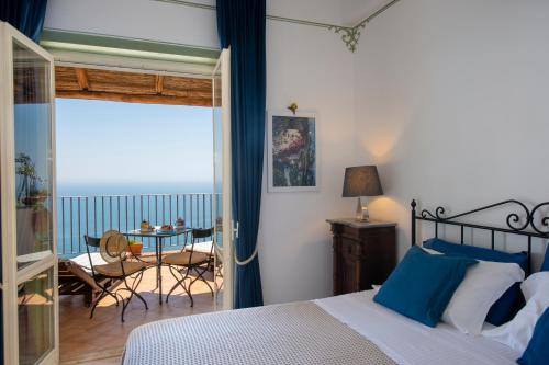 1 dormitorio con cama, mesa y balcón en Amalfi Residence, en Conca dei Marini
