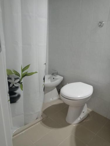 La salle de bains blanche est pourvue de toilettes et d'un lavabo. dans l'établissement Le Perle, à Torre Ovo
