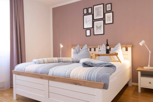 a bedroom with a bed with white cabinets and pictures on the wall at Haus Oselbach- Gemütlich, Zentral, Modern in Zweibrücken
