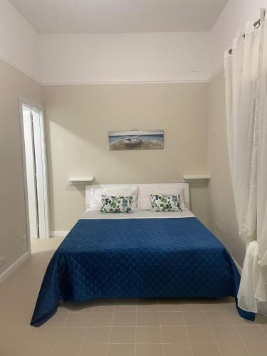 - une chambre avec un lit et une couette bleue dans l'établissement Le Perle, à Torre Ovo