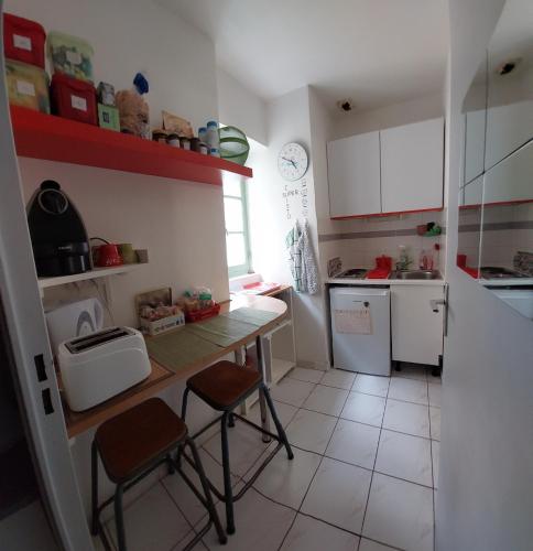 - une petite cuisine avec une table et deux tabourets dans l'établissement Studio Avignon Centre le Saint Pierre, à Avignon