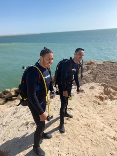 Due uomini in costume da bagno che camminano sulla spiaggia di DAKHLA DIVING CAMP a Dakhla