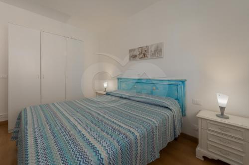 una camera con letto blu e comodino di Appartamenti Maya a Campo - Goelba a Marina di Campo