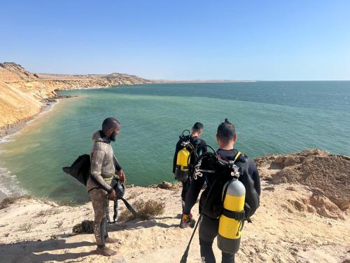 a group of men standing on a hill looking at the water at DAKHLA DIVING CAMP in Dakhla
