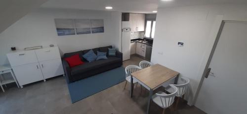 een kleine woonkamer met een bank en een tafel bij El Molino 2 in Muros de Nalón