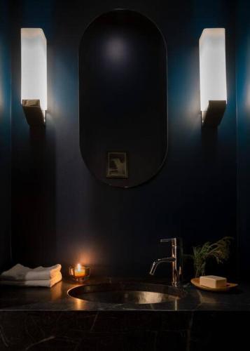 a bathroom with a sink with a mirror and lights at Elegant Townhouse, Hudson center, 3 ensuite baths in Hudson